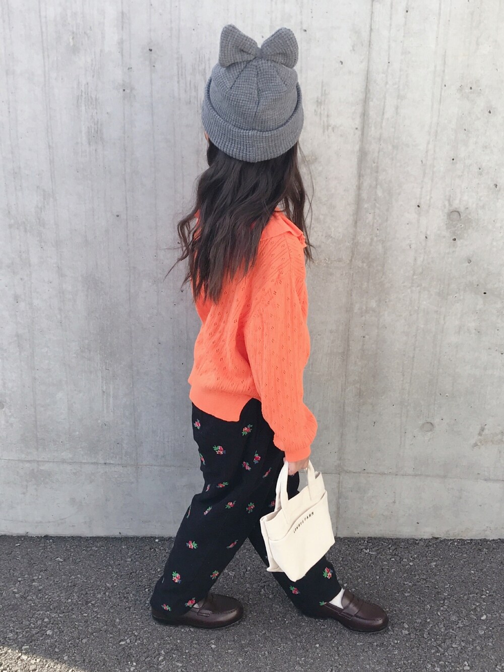 オレンジ系のカーディガン/ボレロ、ブラック系のその他パンツ、ブラウン系のローファーを着用したキッズの秋コーディネートの2枚目の写真