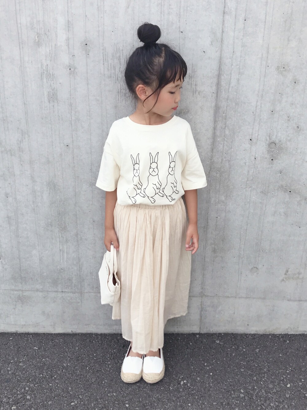 ホワイト系のTシャツ/カットソー、ホワイト系のスカート、ホワイト系のショルダーバッグを着用したキッズの夏コーディネートの3枚目の写真