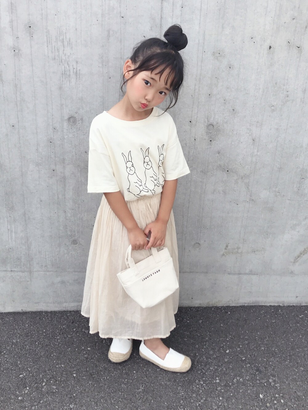 ホワイト系のTシャツ/カットソー、ホワイト系のスカート、ホワイト系のショルダーバッグを着用したキッズの夏コーディネートの2枚目の写真