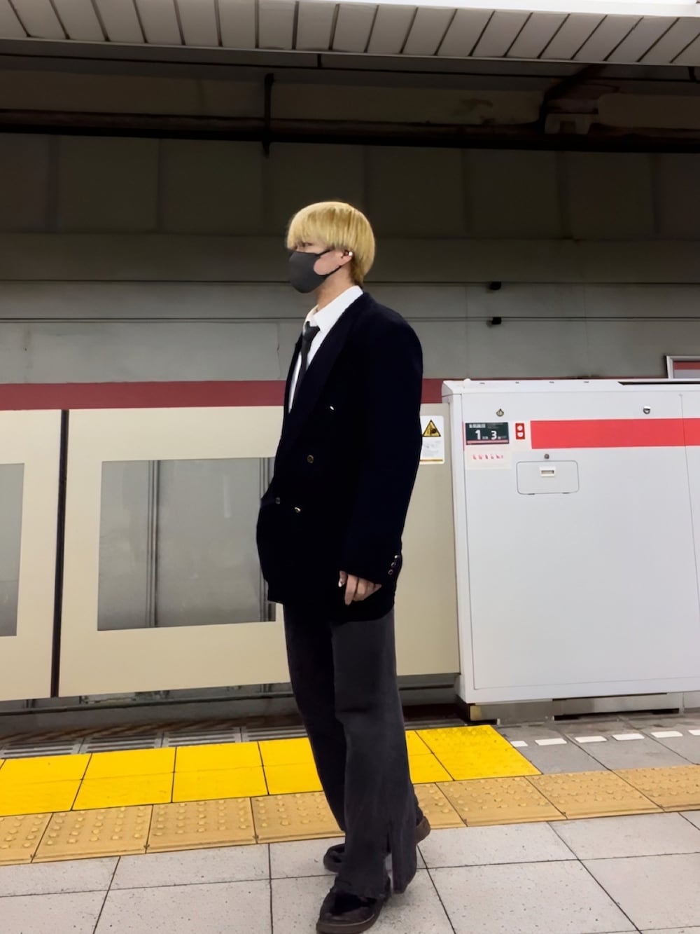 ブラック系のテーラードジャケット、ブラック系のネクタイ、ブラック系のデニムパンツを着用したメンズの春コーディネートの2枚目の写真