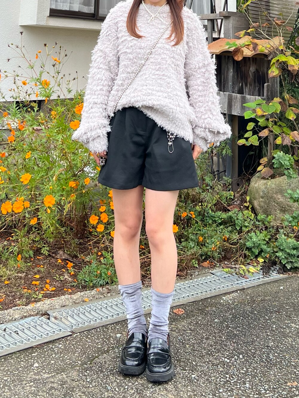 ブラック系のローファー、ブラック系のその他パンツ、シルバー系のショルダーバッグを着用したレディースの秋コーディネートの4枚目の写真