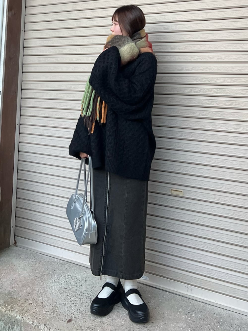 ブラック系のバレエシューズ、ブラック系のスカート、シルバー系のボストンバッグを着用したレディースの冬コーディネートの2枚目の写真