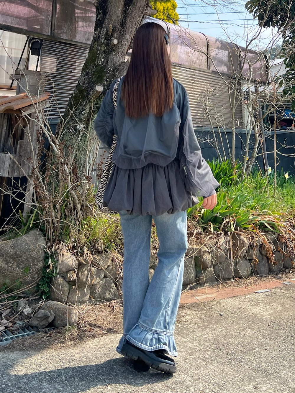 ブラック系のローファー、ブルー系のデニムパンツ、その他のトートバッグを着用したレディースの春コーディネートの3枚目の写真