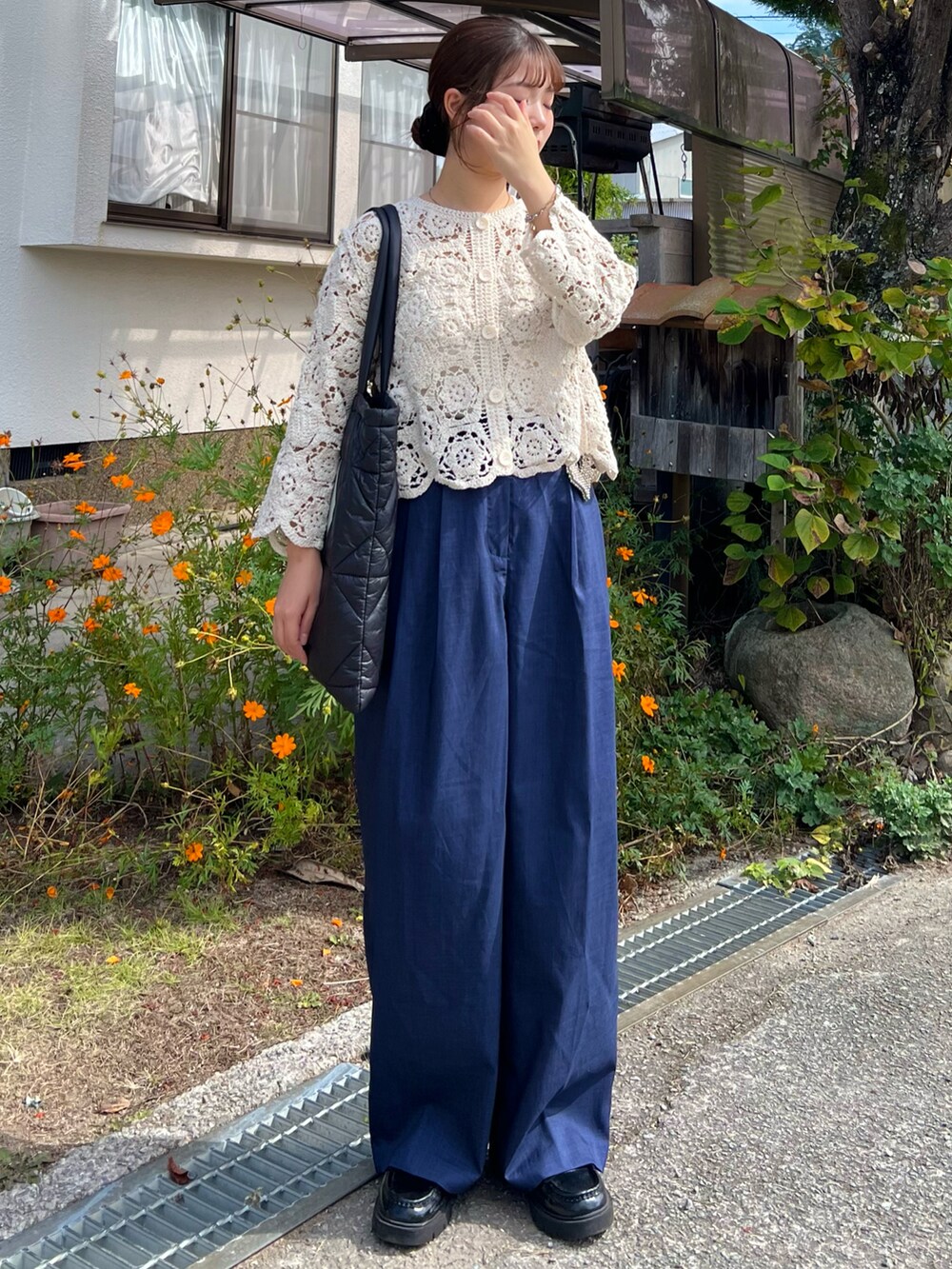 ブラック系のローファー、ブルー系のスラックス、ブラック系のトートバッグを着用したレディースの秋コーディネートの3枚目の写真