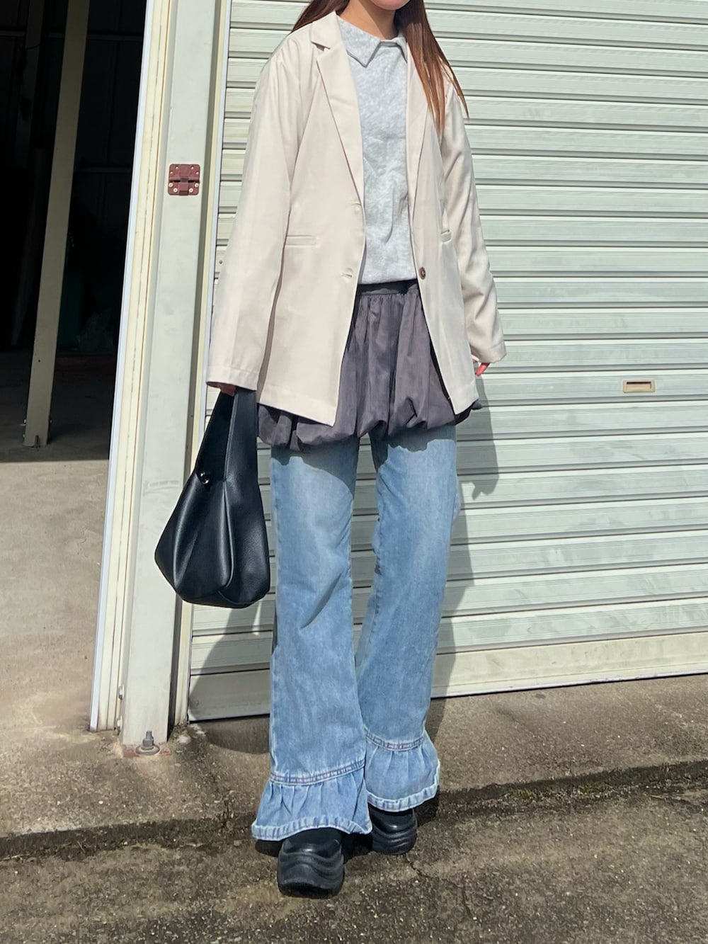 ブルー系のデニムパンツ、グレー系のスウェット、ブラック系のバレエシューズを着用したレディースの春コーディネートの2枚目の写真