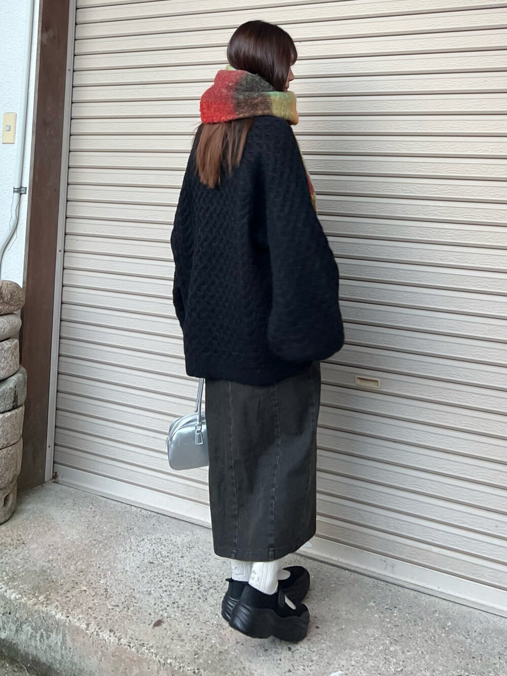 ブラック系のバレエシューズ、ブラック系のスカート、シルバー系のボストンバッグを着用したレディースの冬コーディネートの3枚目の写真