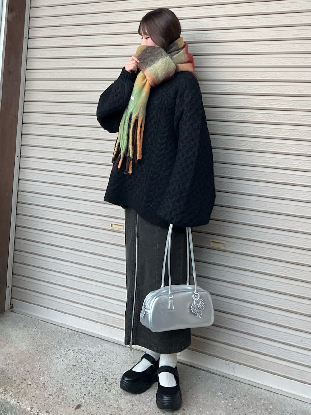 ブラック系のバレエシューズ、ブラック系のスカート、シルバー系のボストンバッグを着用したレディースの冬コーディネートの5枚目の写真