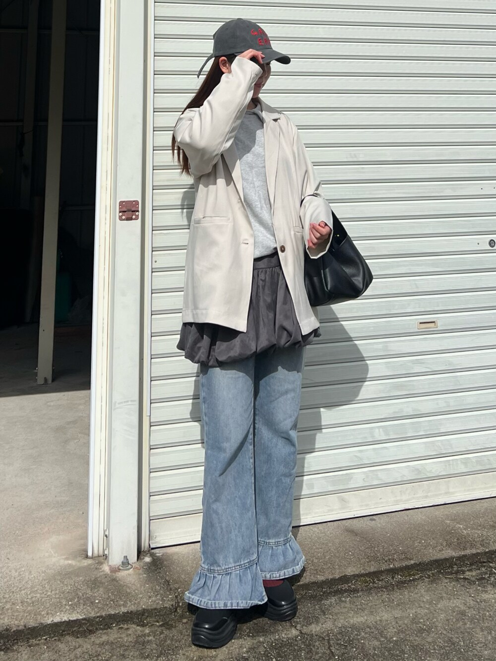 ブルー系のデニムパンツ、グレー系のスウェット、ブラック系のバレエシューズを着用したレディースの春コーディネートの3枚目の写真