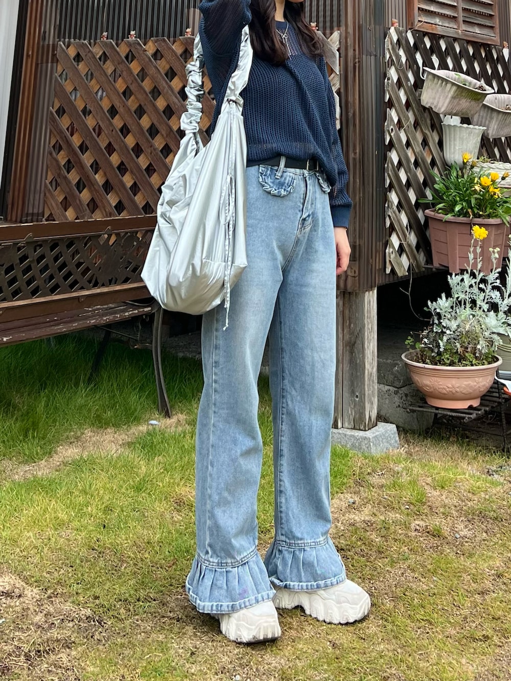 ブルー系のデニムパンツ、ホワイト系のスニーカー、ブルー系のトップスを着用したレディースの夏コーディネートの2枚目の写真