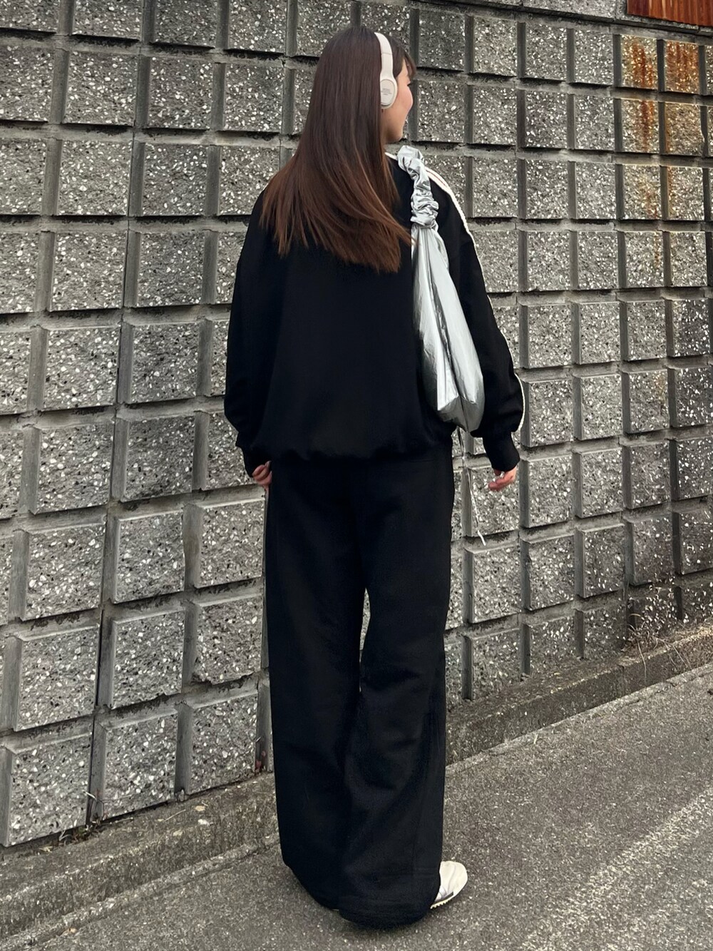 ホワイト系のスニーカー、ブラック系のスウェットパンツ、シルバー系のショルダーバッグを着用したレディースの冬コーディネートの4枚目の写真
