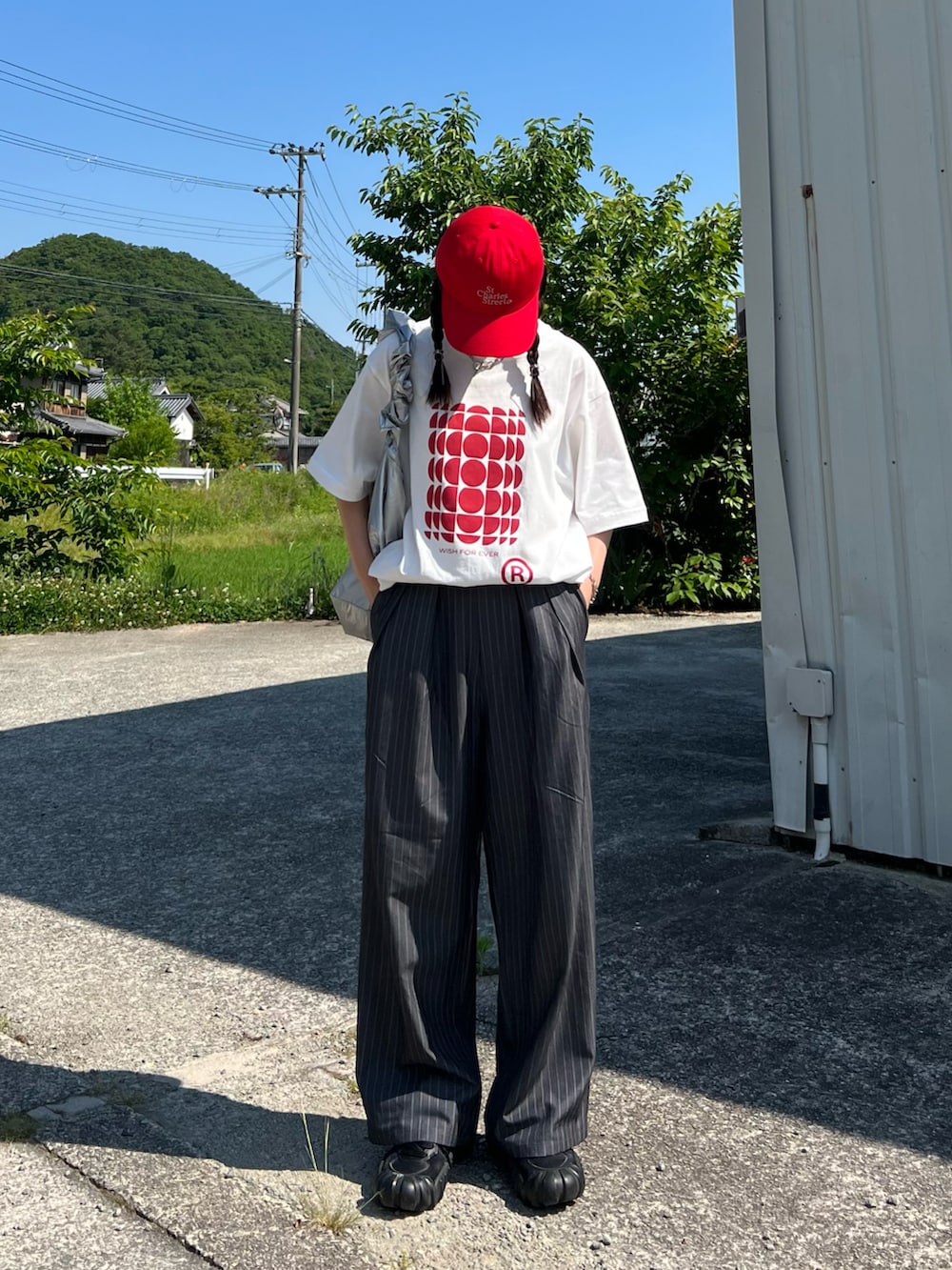 グレー系のスラックス、ブラック系のスニーカー、ホワイト系のTシャツ/カットソーを着用したレディースの夏コーディネートの4枚目の写真