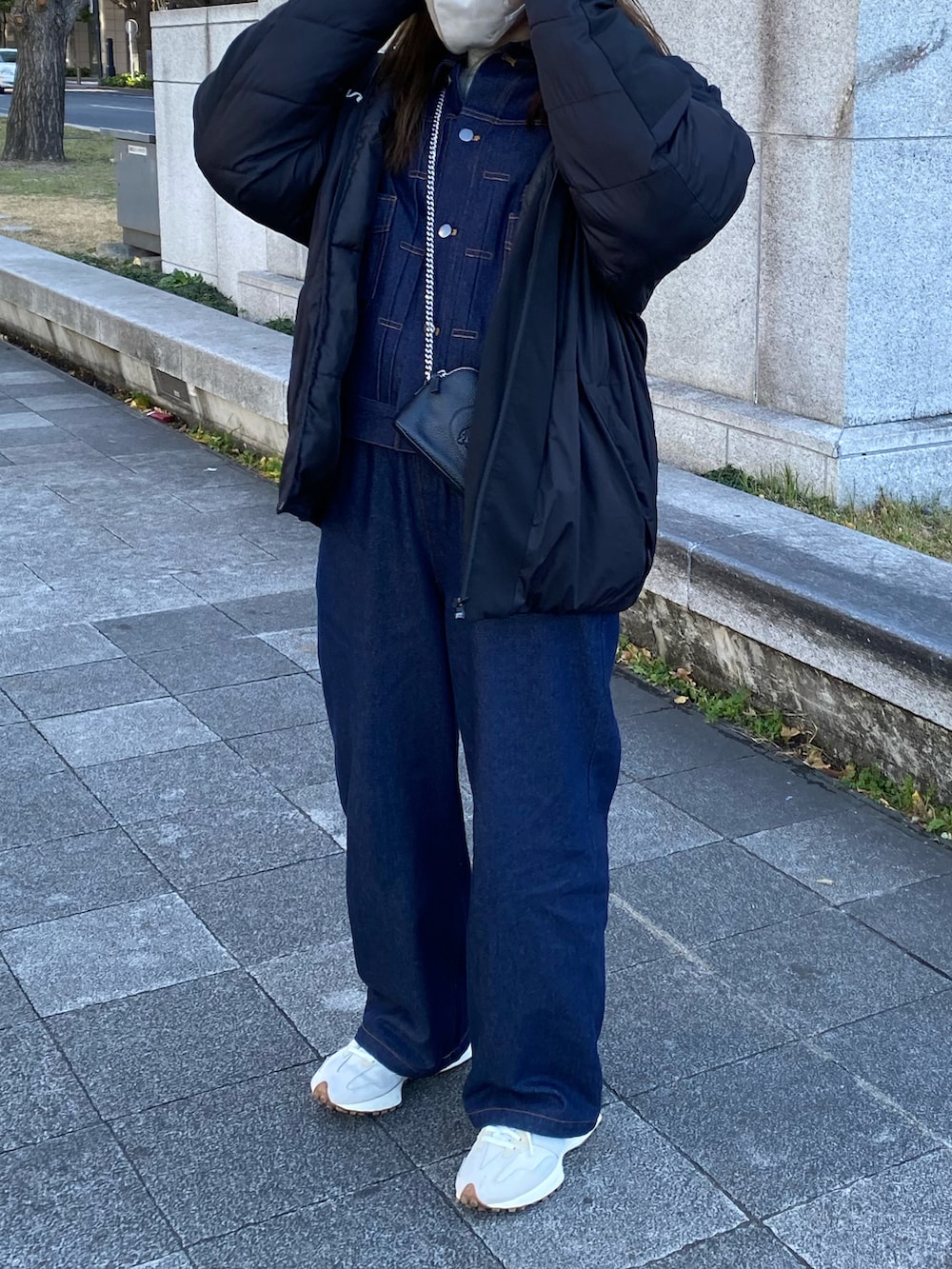 ブルー系のデニムパンツ、ブルー系のデニムジャケット、ホワイト系のスニーカーを着用したレディースの冬コーディネートの2枚目の写真