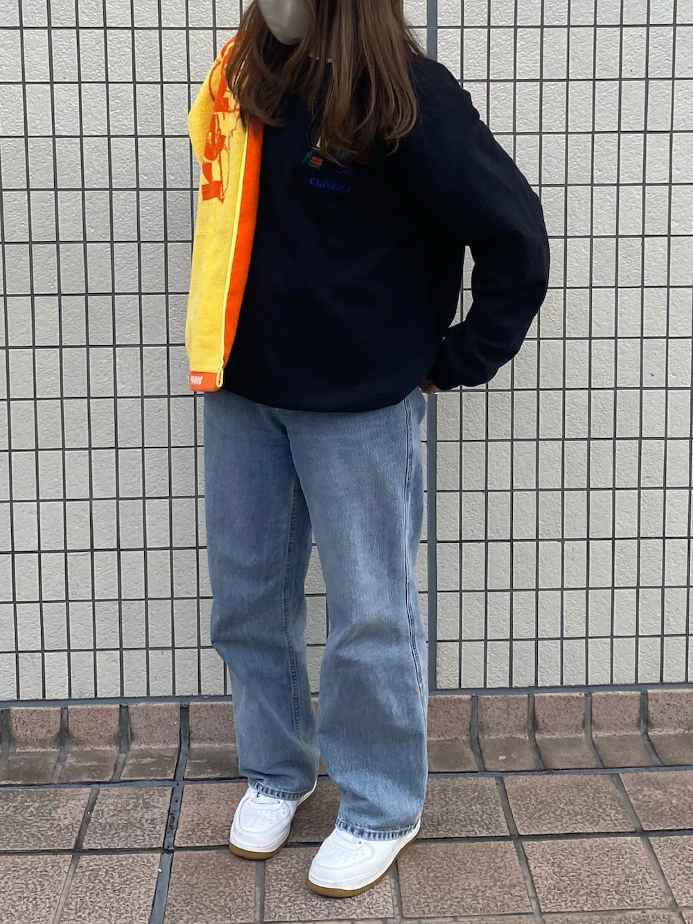 ブラック系のスウェット、ブルー系のデニムパンツ、ホワイト系のスニーカーを着用したレディースの冬コーディネートの2枚目の写真