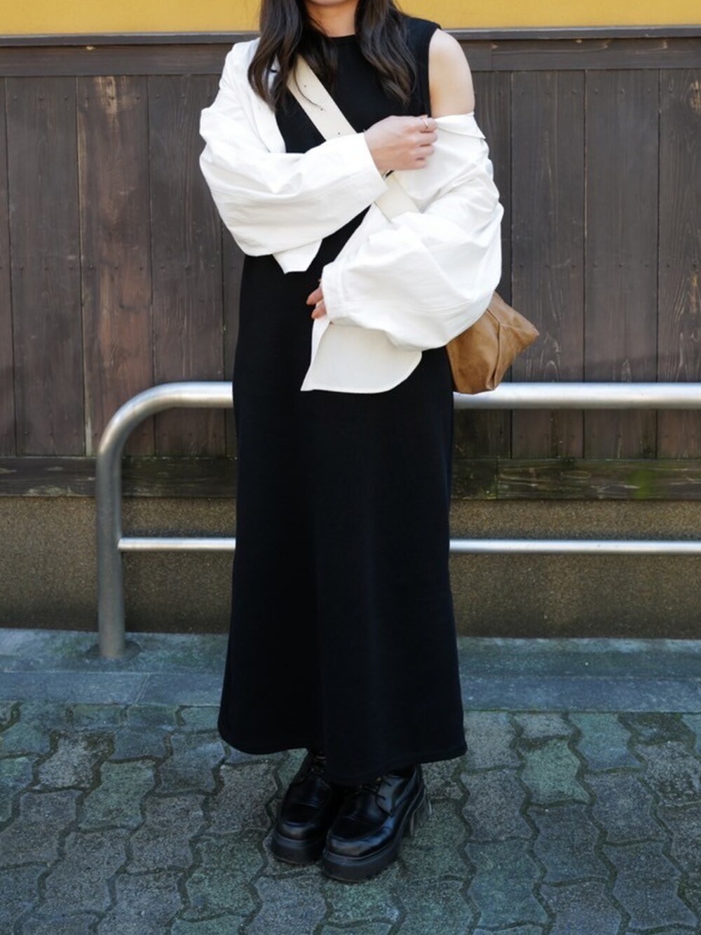 ホワイト系のシャツ/ブラウス、ブラック系のワンピース、ブラック系のブーツを着用したレディースの秋コーディネートの2枚目の写真