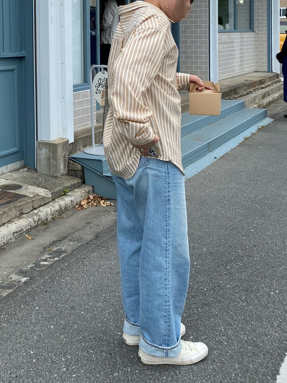 イエロー系のシャツ/ブラウス、グリーン系のバッグ、ホワイト系のスニーカーを着用したレディースの春コーディネートの3枚目の写真