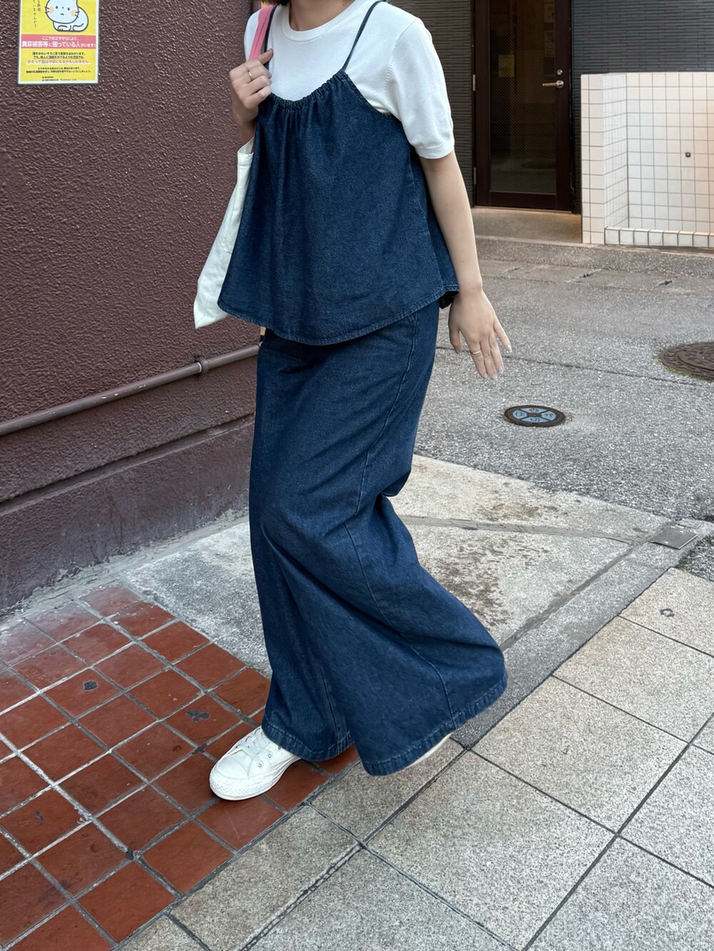 ホワイト系のニット/セーター、ブルー系のキャミソール、ブルー系のデニムパンツを着用したレディースの冬コーディネートの3枚目の写真