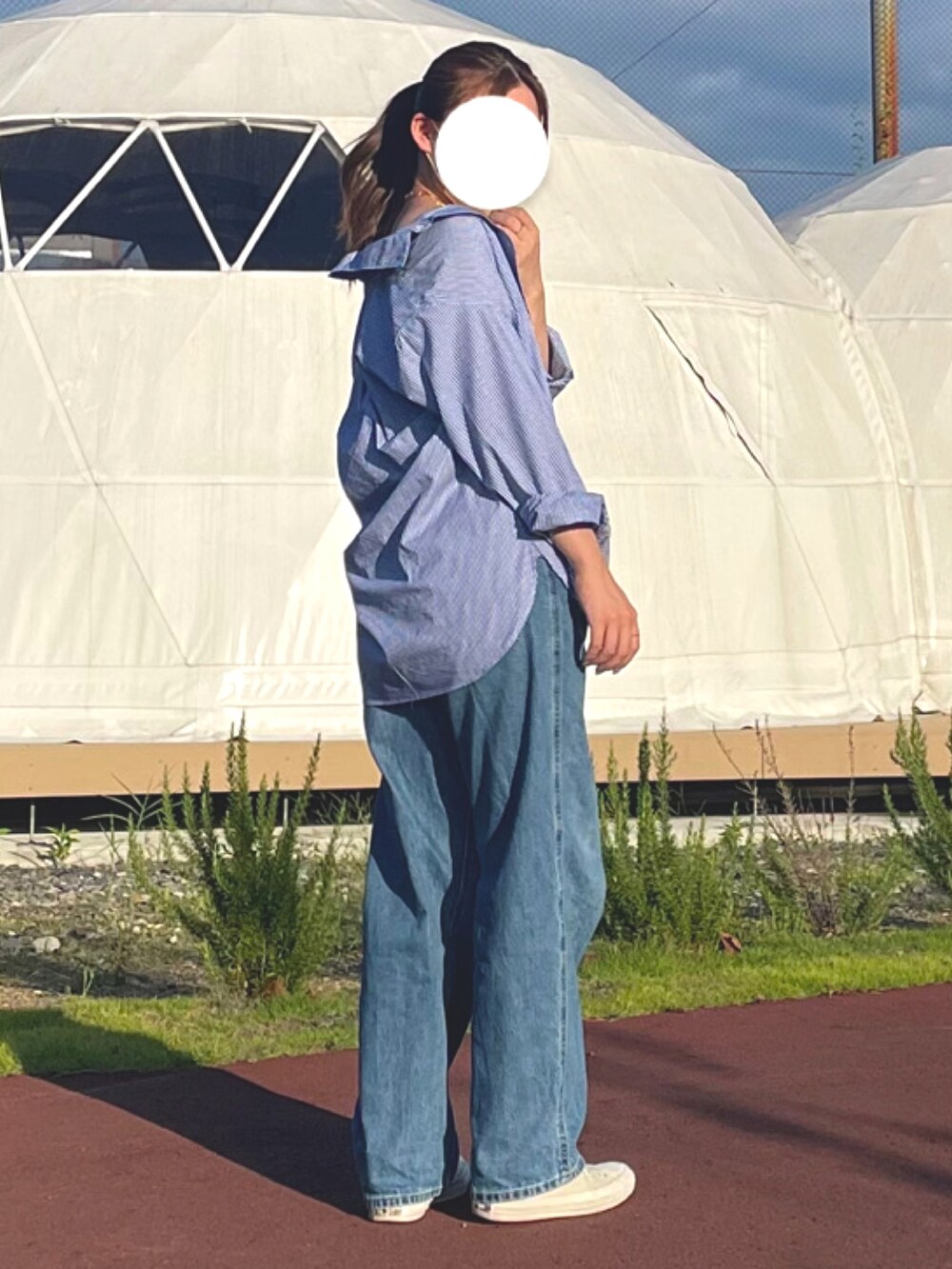 ブルー系のシャツ/ブラウス、ブルー系のデニムパンツ、ホワイト系のスニーカーを着用したレディースの夏コーディネートの2枚目の写真