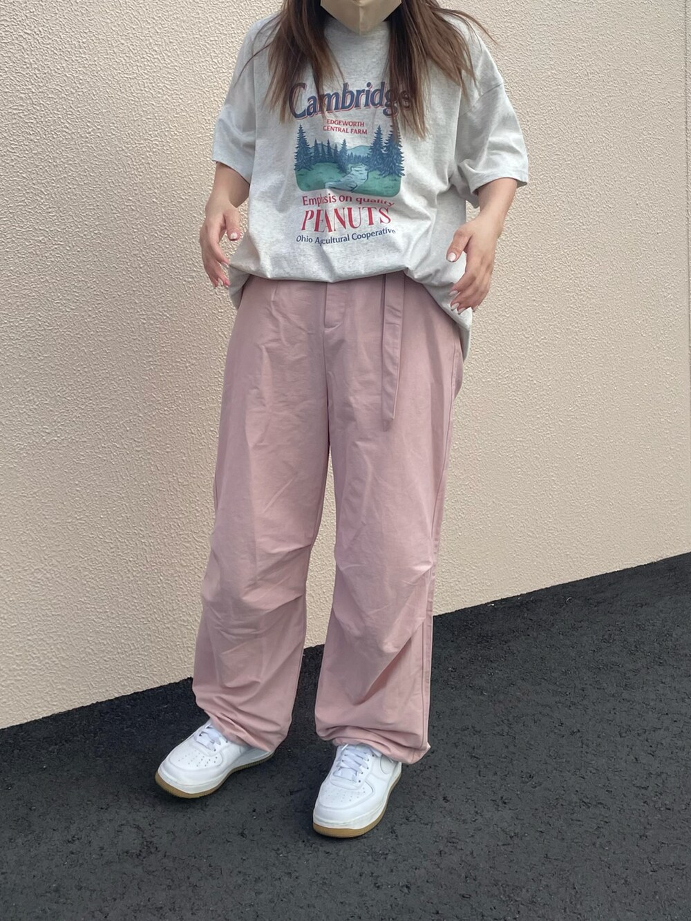 ピンク系のカーゴパンツ、ホワイト系のスニーカー、ベージュ系のTシャツ/カットソーを着用したレディースの夏コーディネートの2枚目の写真