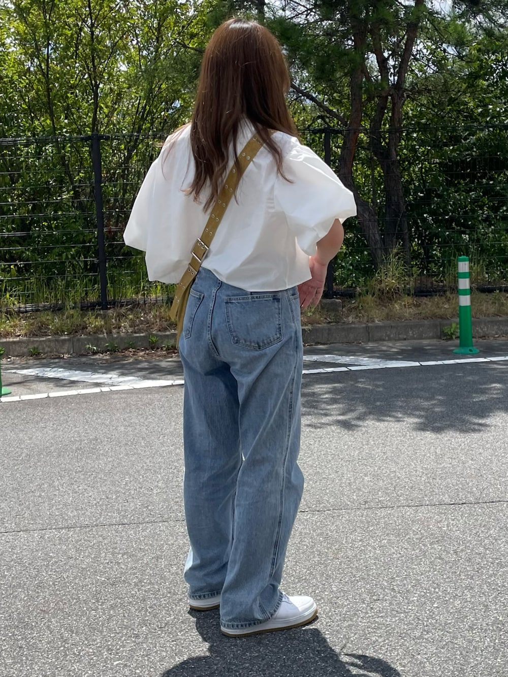 ホワイト系のシャツ/ブラウス、イエロー系のショルダーバッグ、ブルー系のデニムパンツを着用したレディースの夏コーディネートの3枚目の写真