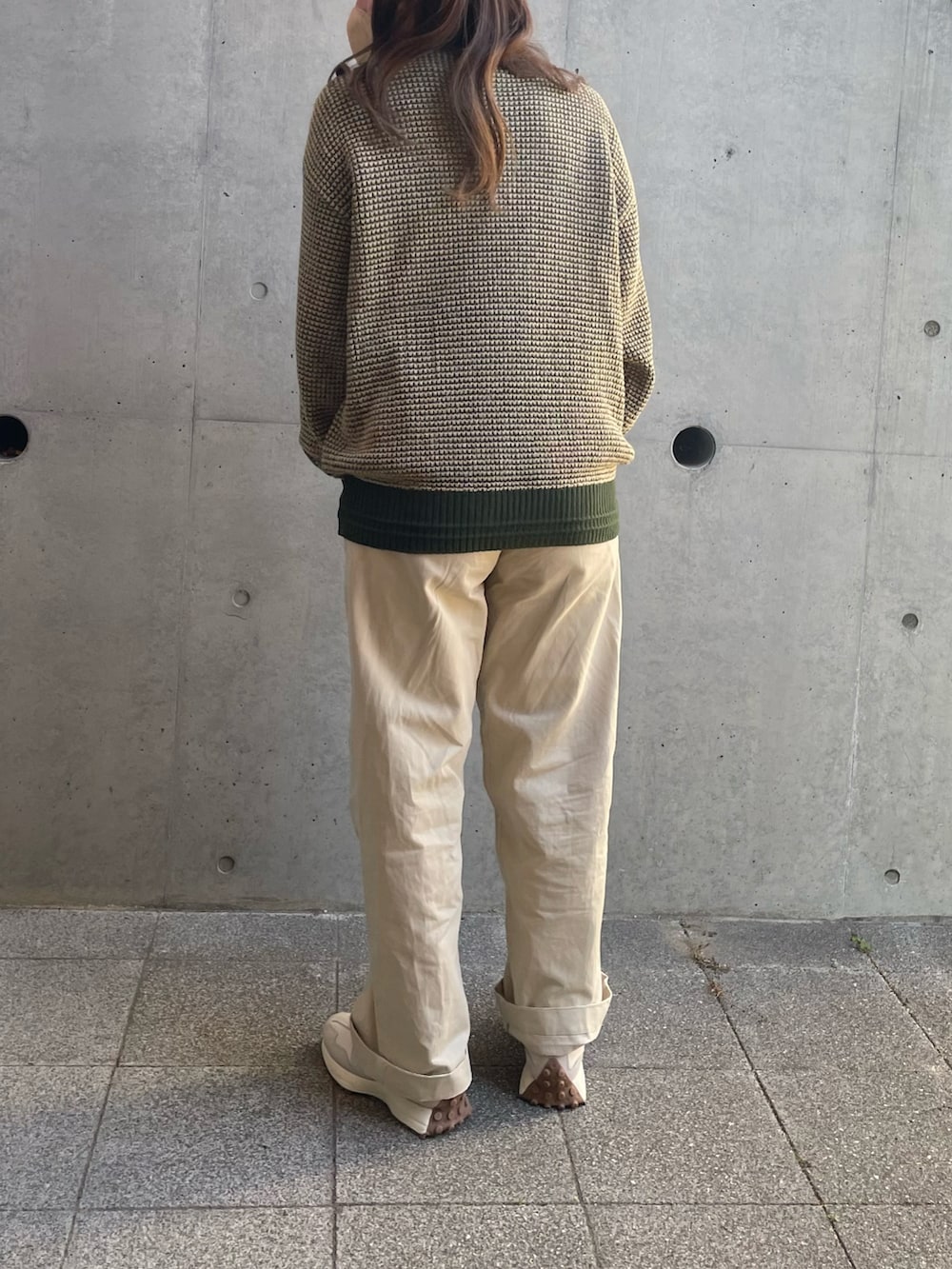 グリーン系のニット/セーター、ベージュ系のチノパンツ、ホワイト系のスニーカーを着用したレディースの冬コーディネートの3枚目の写真