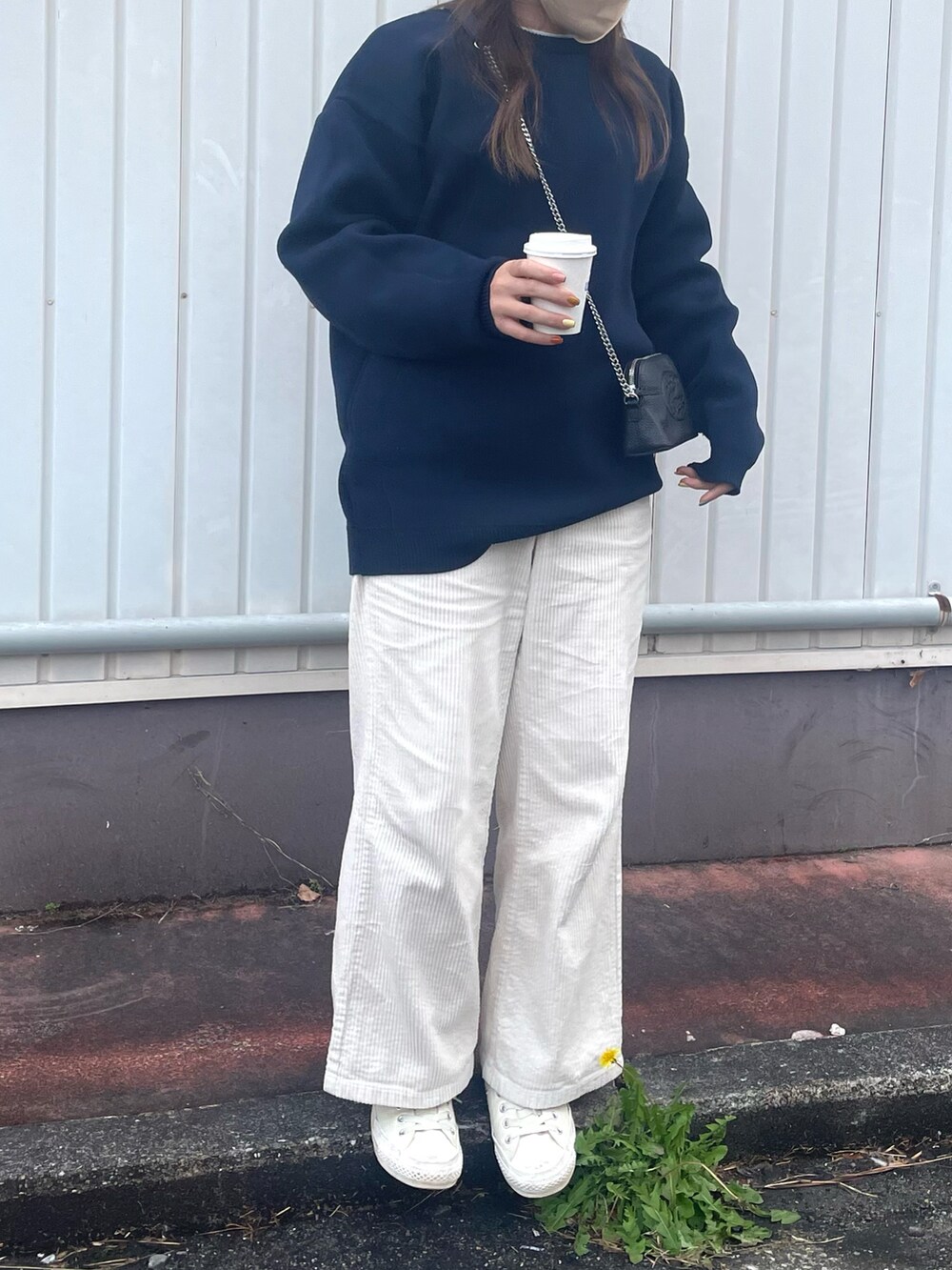 ブルー系のニット/セーター、ホワイト系のパンツ、ブラック系のショルダーバッグを着用したレディースの冬コーディネートの2枚目の写真