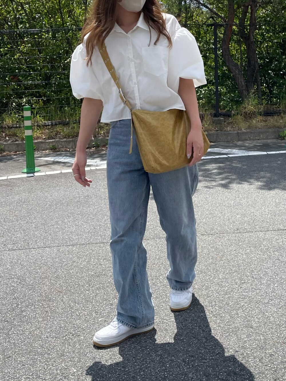 ホワイト系のシャツ/ブラウス、イエロー系のショルダーバッグ、ブルー系のデニムパンツを着用したレディースの夏コーディネートの2枚目の写真
