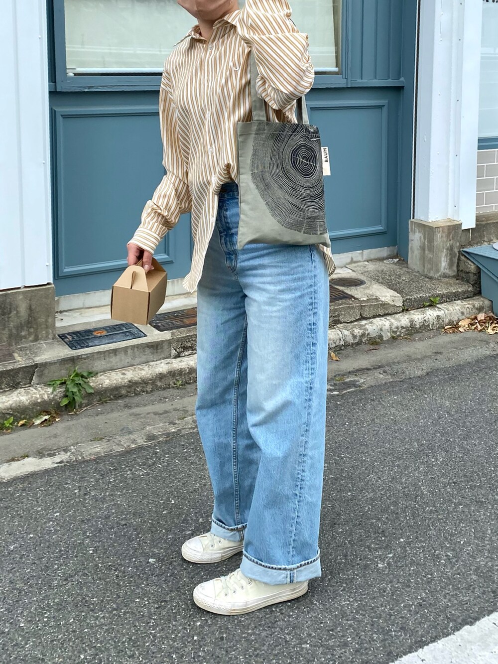 イエロー系のシャツ/ブラウス、グリーン系のバッグ、ホワイト系のスニーカーを着用したレディースの春コーディネートの2枚目の写真