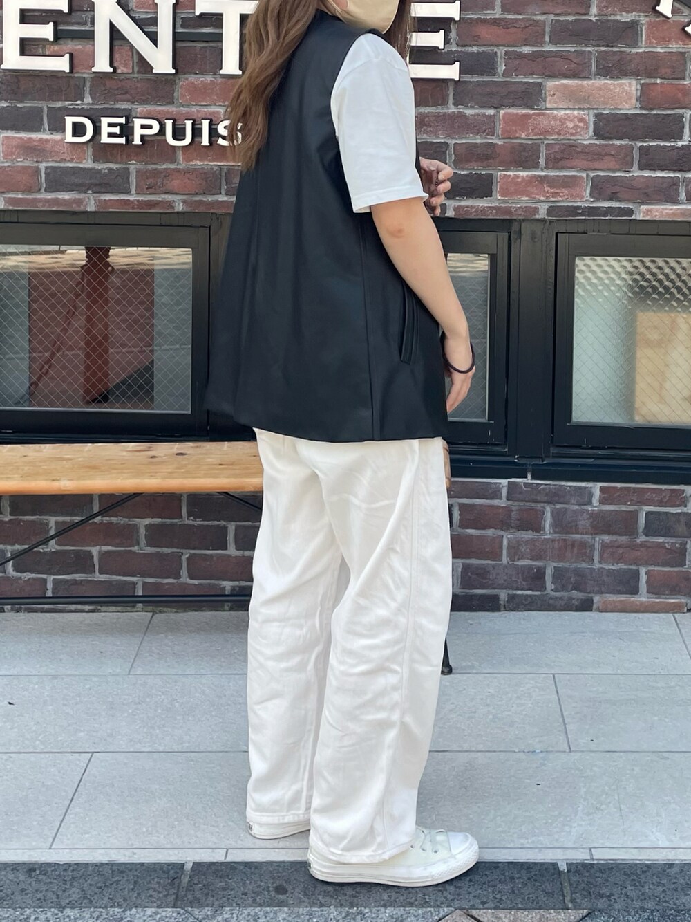 ブラック系のショルダーバッグ、ブラック系のベスト、ホワイト系のデニムパンツを着用したレディースの夏コーディネートの2枚目の写真