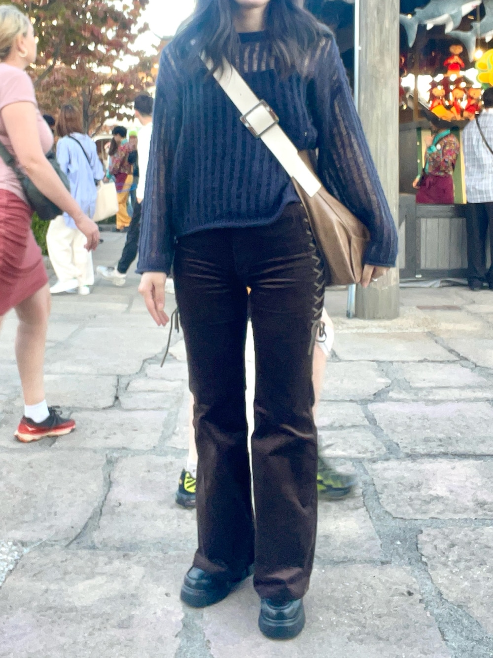 ブラウン系のショルダーバッグ、ブラウン系のその他パンツ、ブラック系のブーツを着用したレディースの秋コーディネートの3枚目の写真