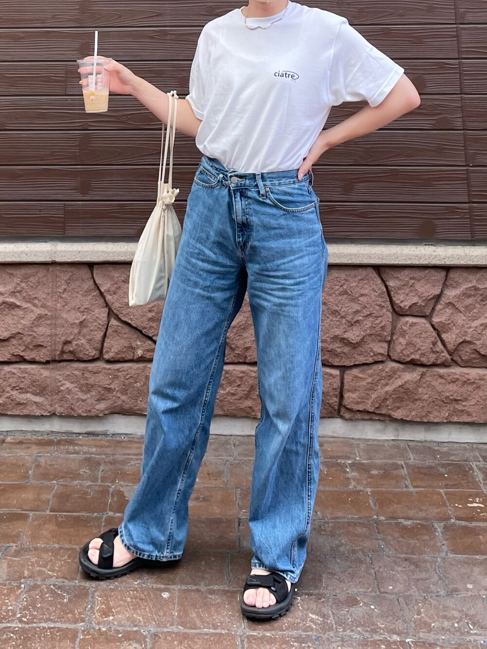 ホワイト系のTシャツ/カットソー、ホワイト系のキャミソール、ベージュ系のハンドバッグを着用したレディースの夏コーディネートの2枚目の写真