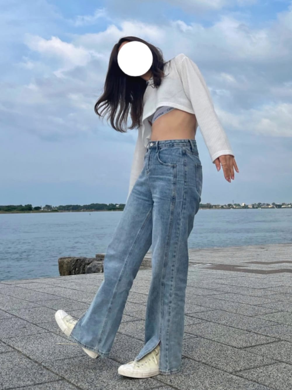 ホワイト系のニット/セーター、ブルー系のデニムパンツ、ホワイト系のスニーカーを着用したレディースの夏コーディネートの2枚目の写真