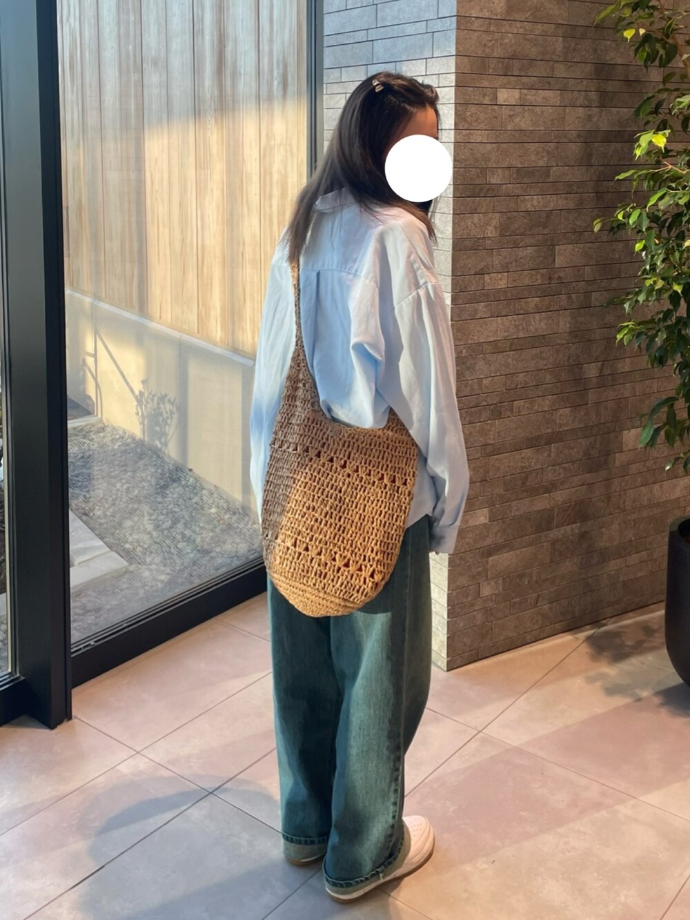 ブルー系のシャツ/ブラウス、ベージュ系のかごバッグ、ブルー系のデニムパンツを着用したレディースの夏コーディネートの3枚目の写真