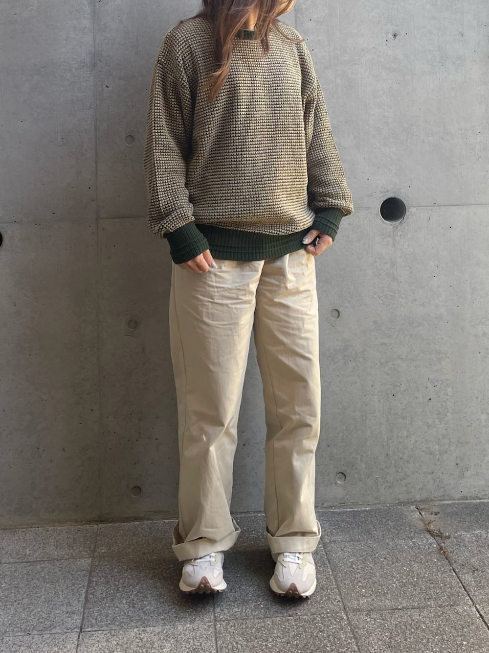 グリーン系のニット/セーター、ベージュ系のチノパンツ、ホワイト系のスニーカーを着用したレディースの冬コーディネートの2枚目の写真