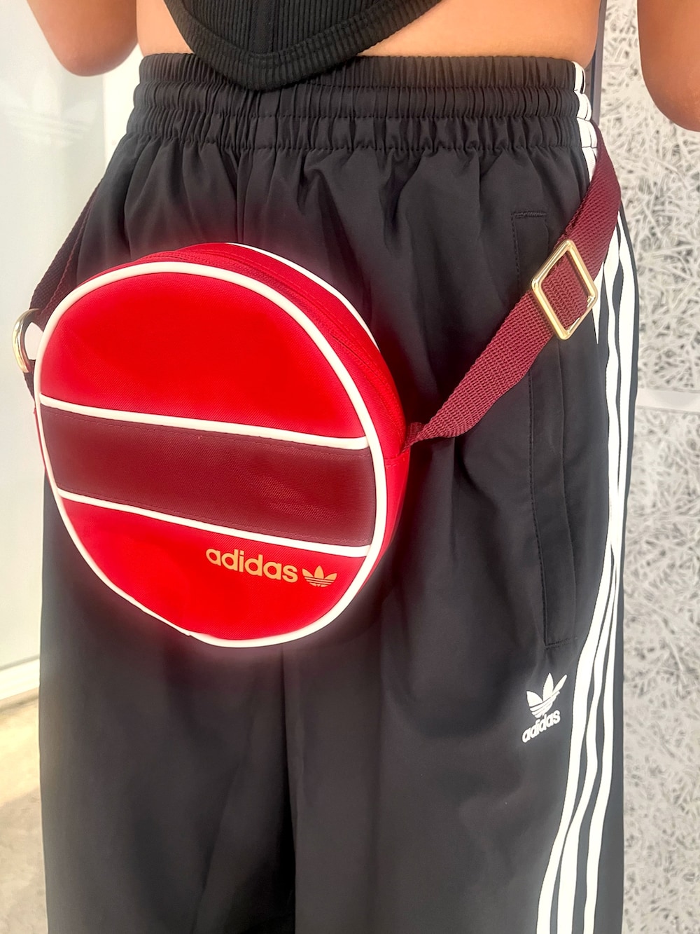 ブラック系のTシャツ/カットソー、ブラック系のスウェットパンツ、レッド系のショルダーバッグを着用したレディースの秋コーディネートの4枚目の写真