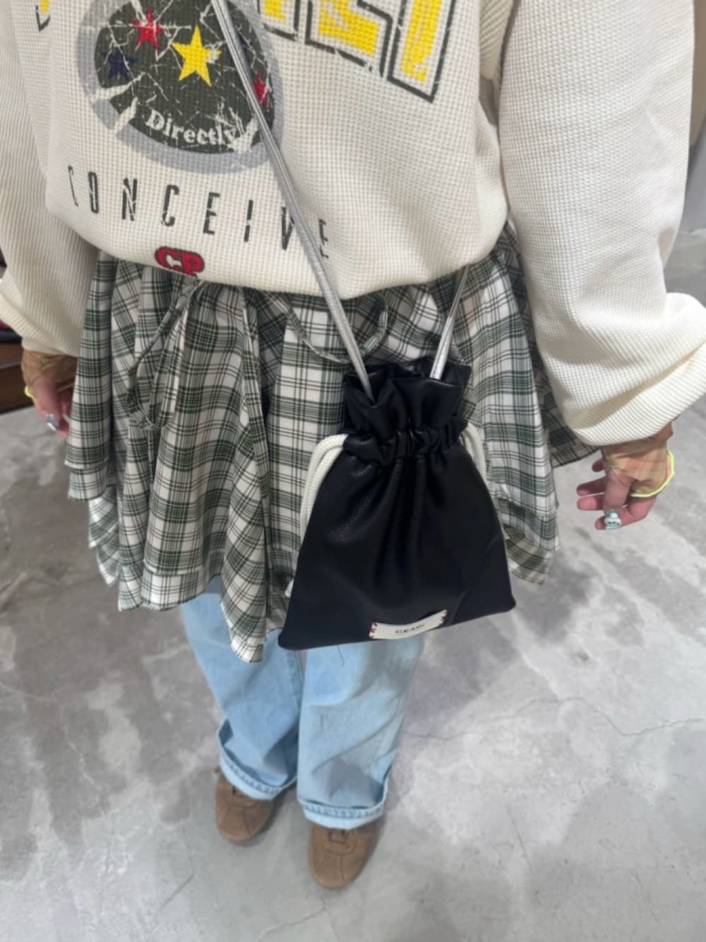 ホワイト系のTシャツ/カットソー、グリーン系のスカート、ブラック系のショルダーバッグを着用したレディースの夏コーディネートの4枚目の写真
