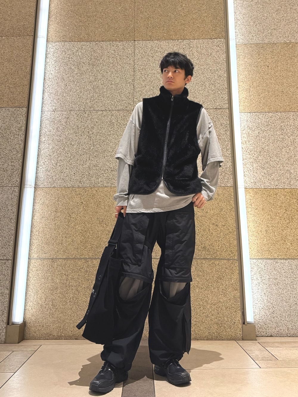 ブラック系のベスト、グレー系のTシャツ/カットソー、ブラック系のトートバッグを着用したメンズの秋コーディネートの2枚目の写真