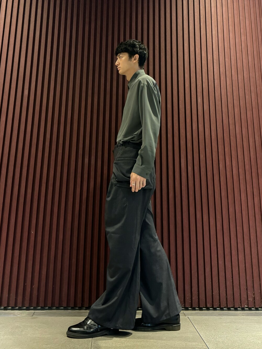 グレー系のスラックス、グリーン系のシャツ/ブラウス、ブラック系のドレスシューズを着用したメンズの秋コーディネートの2枚目の写真