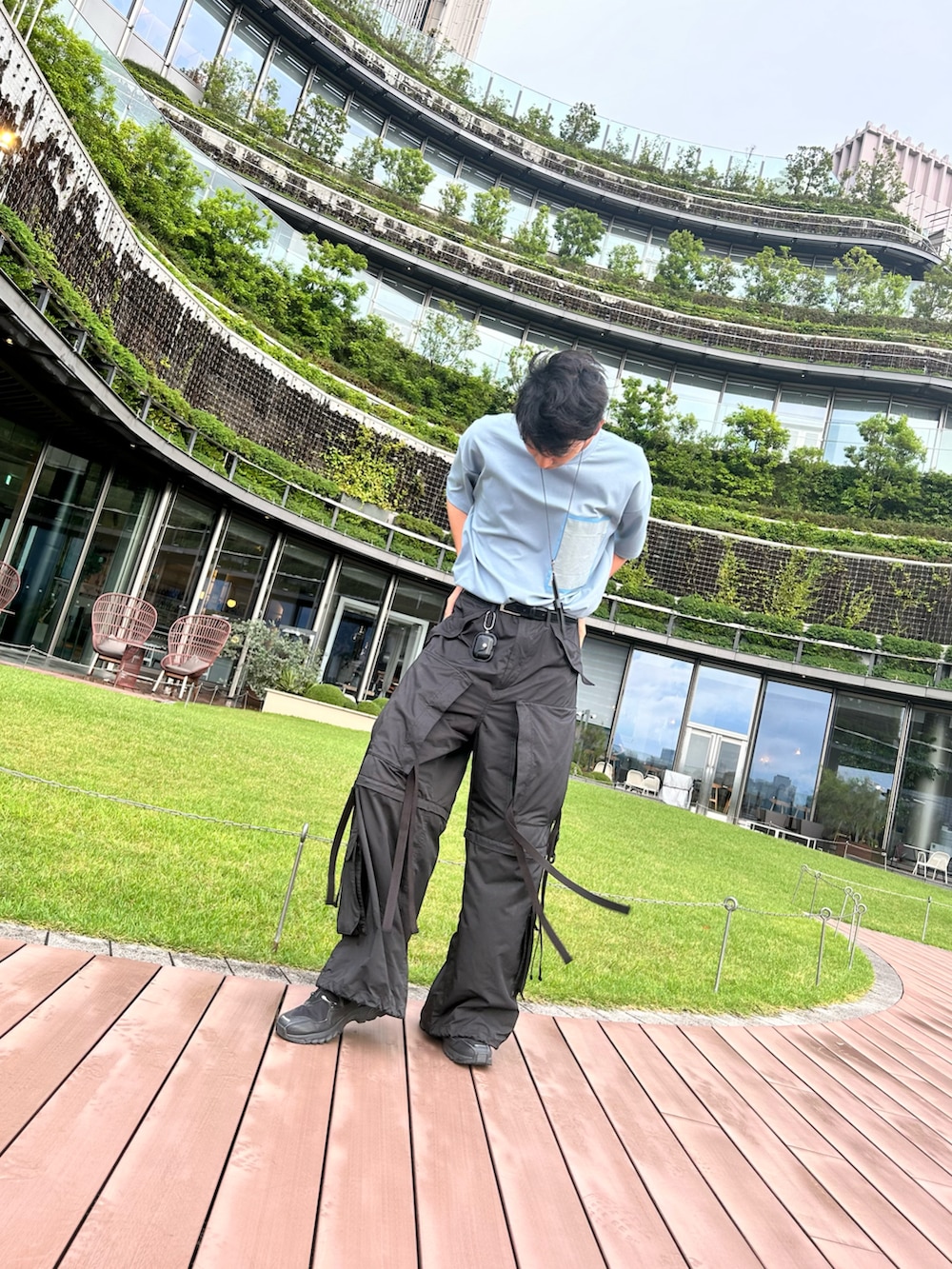 ブルー系のTシャツ/カットソー、ブラック系のカーゴパンツ、ブラック系のスニーカーを着用したメンズの夏コーディネートの2枚目の写真