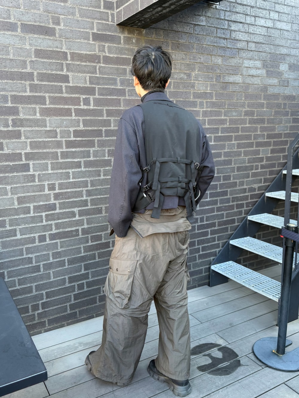 ブラウン系のオールインワン・サロペット、ブルー系のブルゾン、ブラック系のベストを着用したメンズの春コーディネートの2枚目の写真