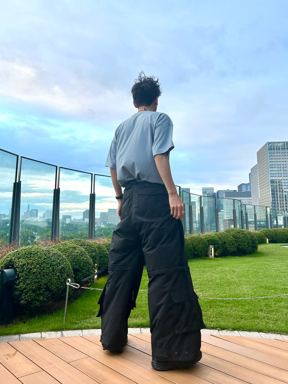 ブルー系のTシャツ/カットソー、ブラック系のカーゴパンツ、ブラック系のスニーカーを着用したメンズの夏コーディネートの3枚目の写真