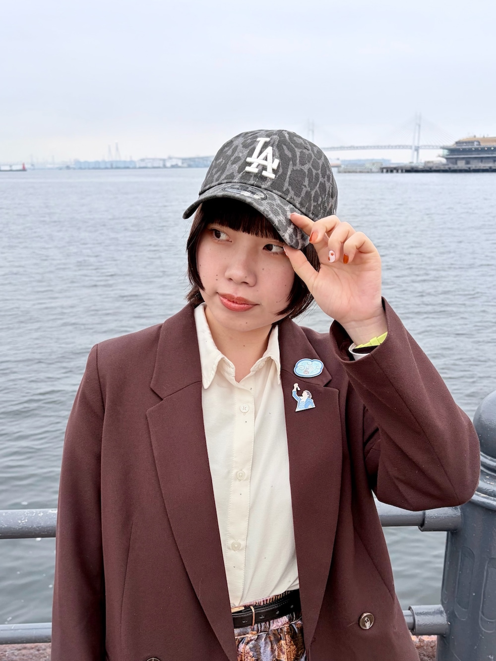 ブラウン系のテーラードジャケット、パープル系のパンツ、ブラック系のスニーカーを着用したレディースの春コーディネートの3枚目の写真