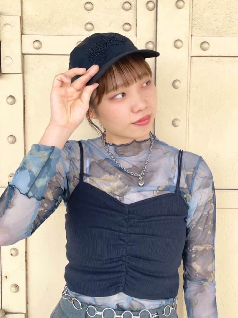 ブルー系のTシャツ/カットソー、ブラック系のスニーカー、ブラック系のキャップを着用したレディースの夏コーディネートの3枚目の写真