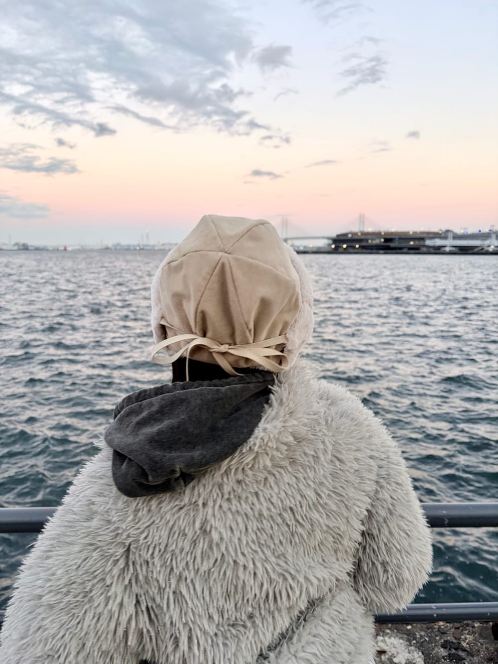 ブラック系のデニムパンツ、ブラック系のスニーカー、ホワイト系のハットを着用したレディースの冬コーディネートの6枚目の写真