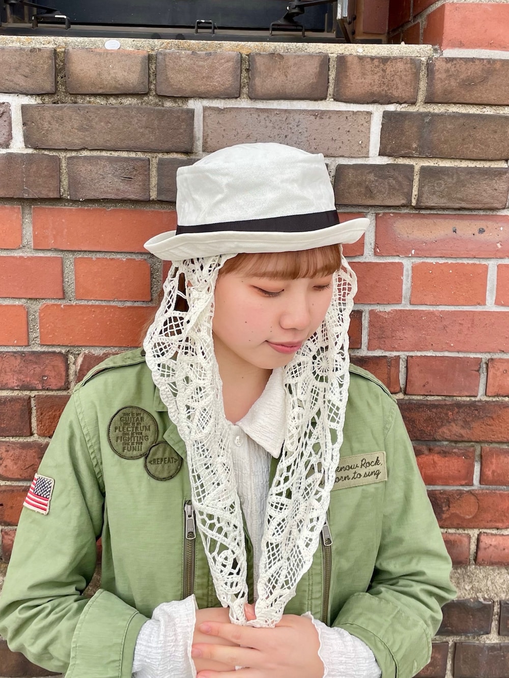 グリーン系のジャケット/アウター、ホワイト系のスカート、ホワイト系のスニーカーを着用したレディースの春コーディネートの3枚目の写真