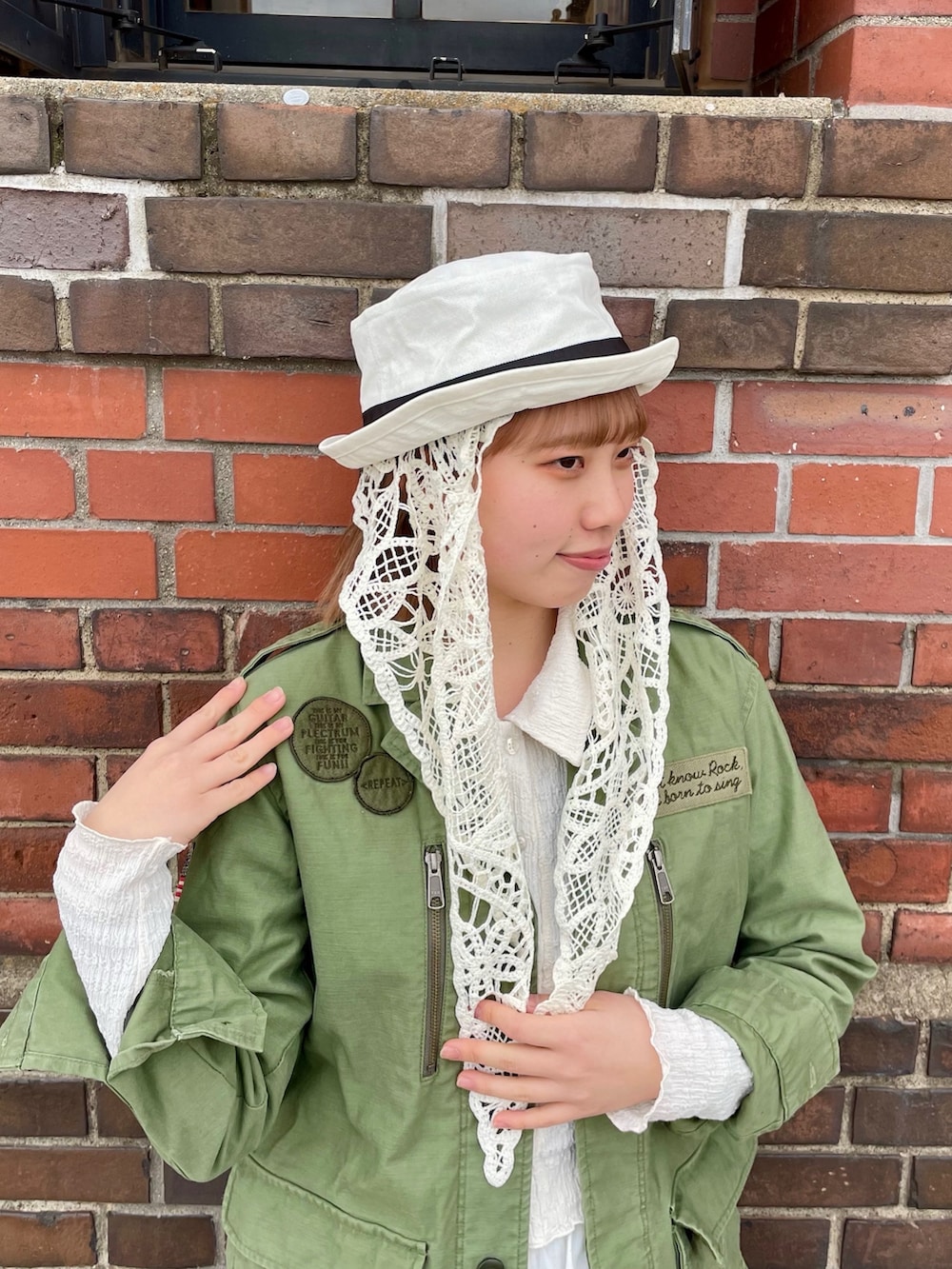 グリーン系のジャケット/アウター、ホワイト系のスカート、ホワイト系のスニーカーを着用したレディースの春コーディネートの5枚目の写真