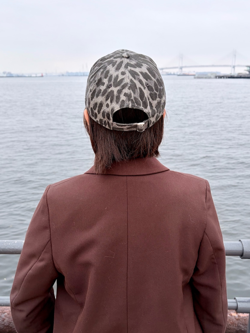 ブラウン系のテーラードジャケット、パープル系のパンツ、ブラック系のスニーカーを着用したレディースの春コーディネートの7枚目の写真