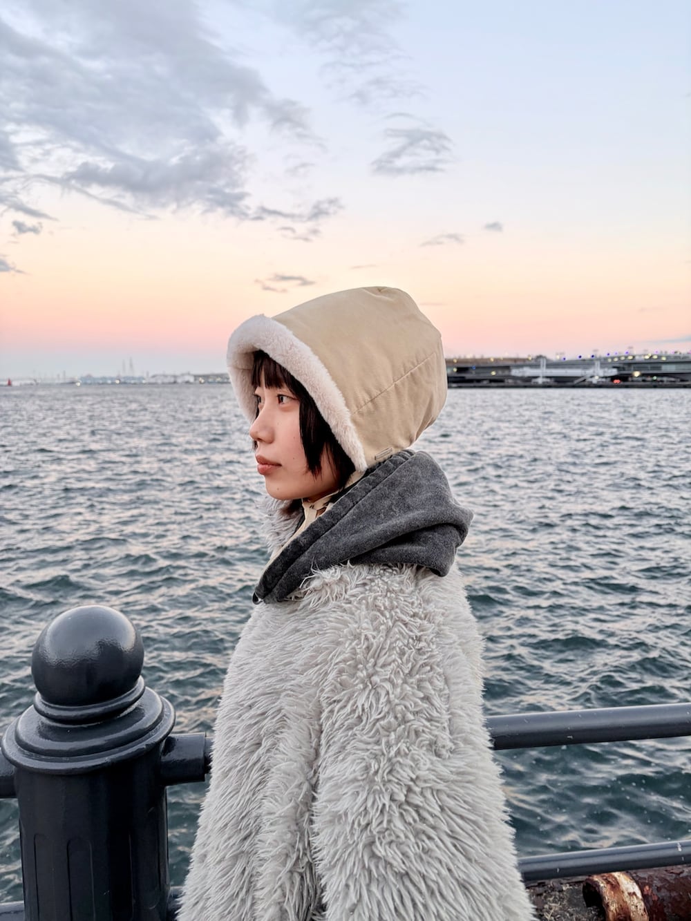 ブラック系のデニムパンツ、ブラック系のスニーカー、ホワイト系のハットを着用したレディースの冬コーディネートの5枚目の写真