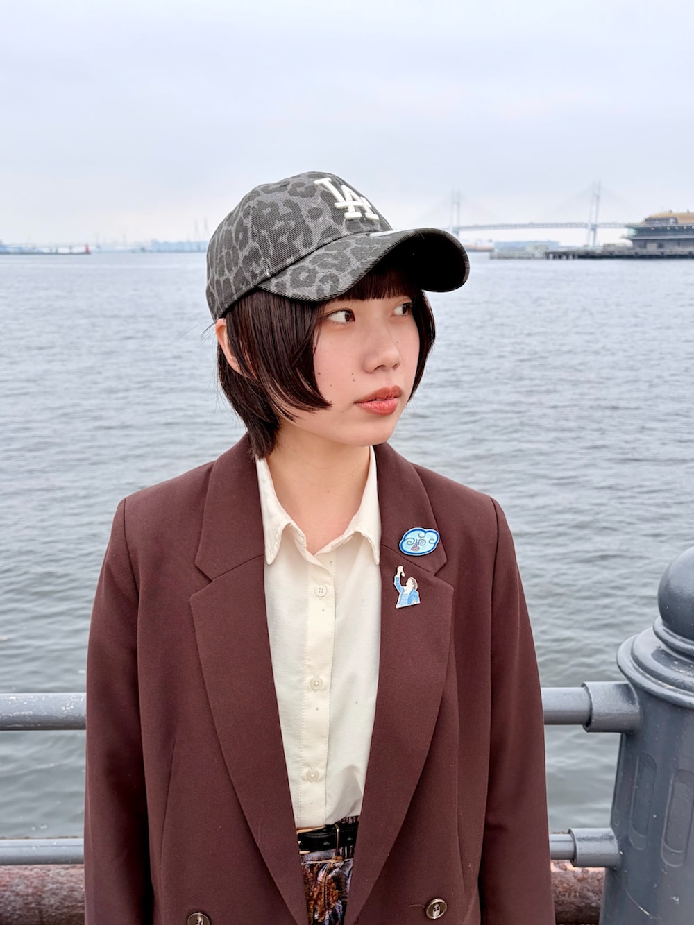 ブラウン系のテーラードジャケット、パープル系のパンツ、ブラック系のスニーカーを着用したレディースの春コーディネートの4枚目の写真