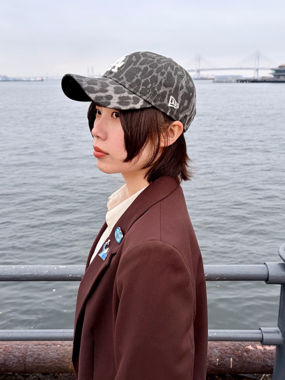 ブラウン系のテーラードジャケット、パープル系のパンツ、ブラック系のスニーカーを着用したレディースの春コーディネートの6枚目の写真