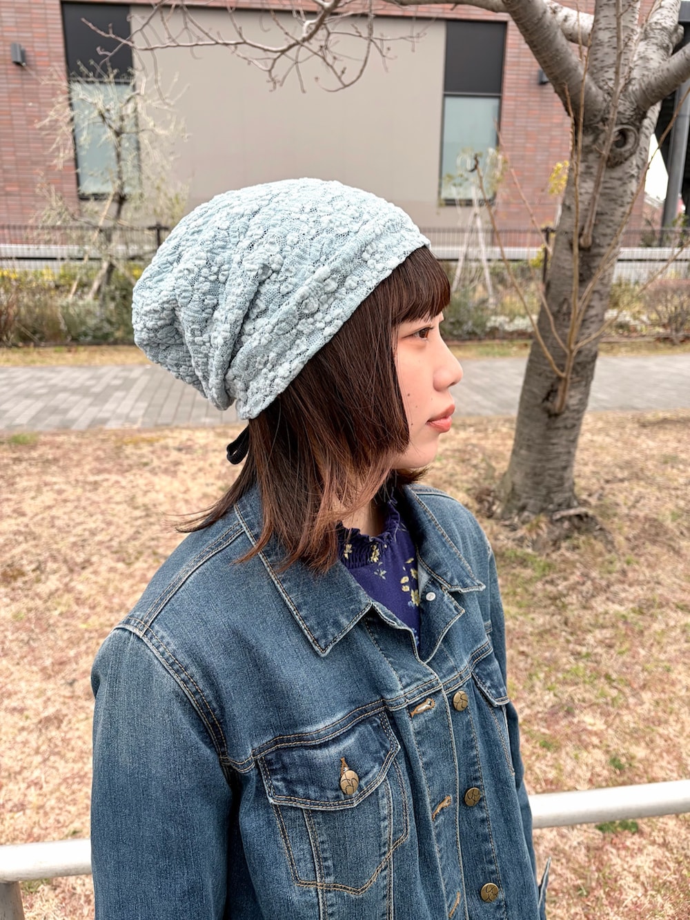 ブルー系のデニムジャケット、ブルー系のデニムパンツ、ホワイト系のスニーカーを着用したレディースの冬コーディネートの4枚目の写真